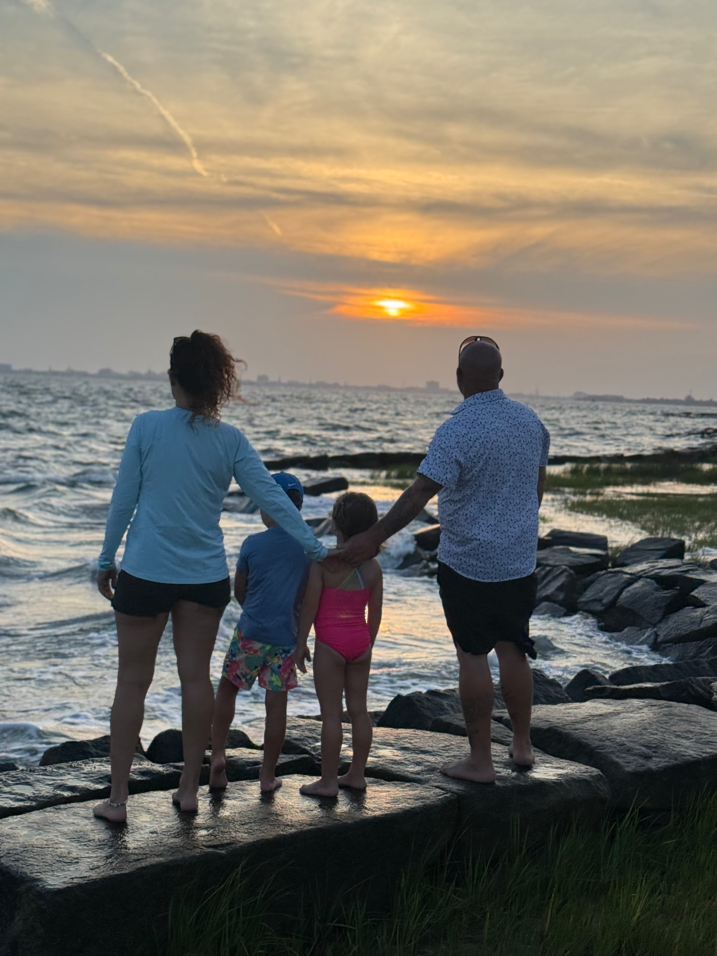 Family watching the sunset over the water near Mount Pleasant, South Carolina